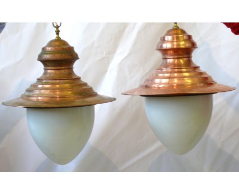 A pair of industrial copper ceiling lamps Each with copper hoods, with milk glass pendant shaped shades, height 75cm, diamete