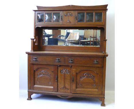 A British Arts & Crafts light oak sideboardHaving back section with two glazed doors above mirror back, the base section with