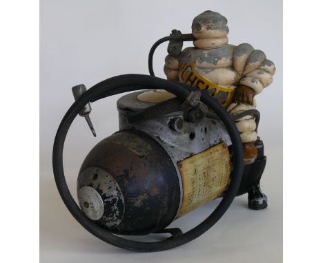 An original circa 1920's Michelin air compressorModelled with a Michelin man seated on a bullet shaped compressor, height 26c