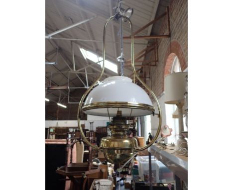 A VICTORIAN HANGING 'HARP' OIL LAMP with brass frame and white shade (wired for electricity)