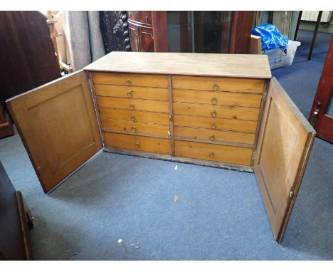 A 19TH CENTURY SIMULATED OAK COLLECTORS CABINET with twelve drawers with brass ring handles enclosed by doors 54cm high x 92c