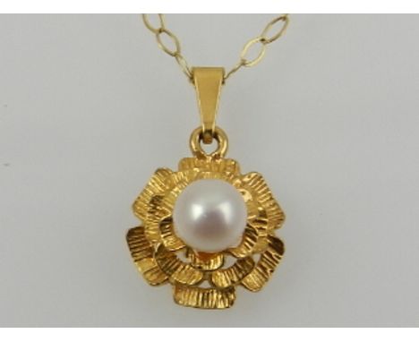 A 9 carat yellow gold and pearl set cluster pendant, suspended on a 9 carat yellow gold chain. 