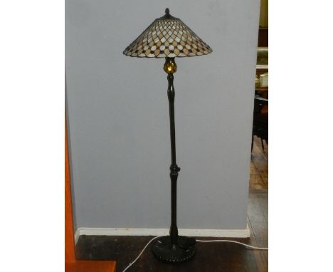 A Tiffany style floor lamp, having leaded coloured glass shade, raised on a shaped cast metal base, 153. H. cm 