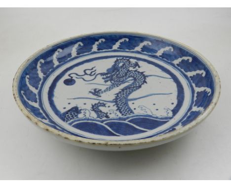 A late 19th / early 20th century Chinese blue and white porcelain charger, decorated with a dragon chasing a flaming pearl. D