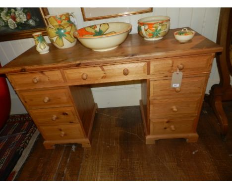 A 20th century pine pedestal desk, with single long drawer flanked by four graduated drawers, H. 83cm, W. 137cm, D.54cm