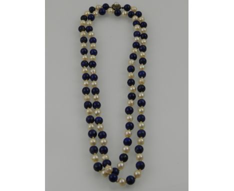 A lapis lazuli and pearl beaded opera length necklace, having white metal clasp set with a pearl. 