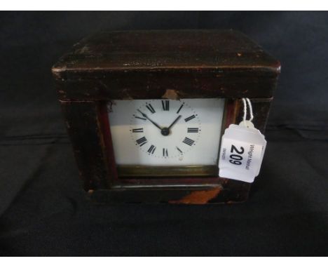 A late 19th/early 20th Century brass cased carriage clock with white enamel dial with Roman numerals fitted with a looped fol