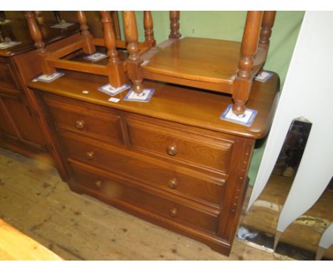 An Ercol medium elm four drawer chest with turned knob handles 