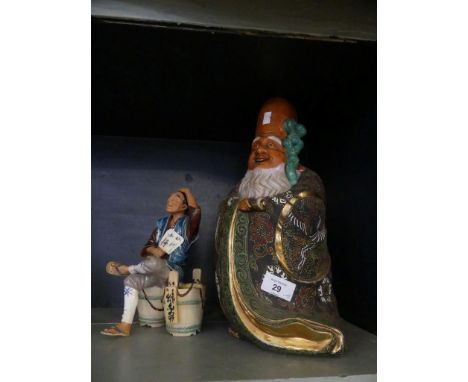 A Japanese satsuma figure of a wise man together with a further ceramic figure of a man seated on buckets (2) 