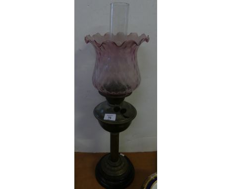 An early 20th Century oil lamp, with tinted frilled glass shade over a brass body and plinth base 
