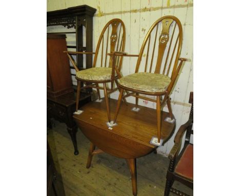 An Ercol medium elm dropleaf table with two accompanying chairs 