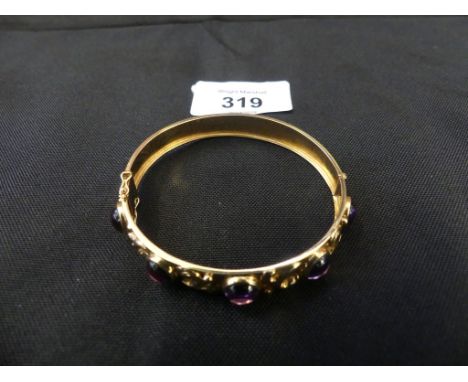 A 1950s 18ct gold synthetic colour change sapphire bangle, the synthetic colour change sapphire cabochons with scrolling spac