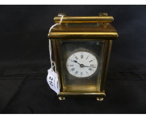 A 20th Century brass framed French carriage clock the silvered face with central white enamel dial with Roman and Arabic nume