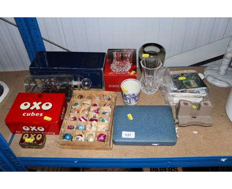 A Mayflower glass ship in bottle ornament, two OXO tins, box of vintage Christmas decorations, case of pastry forks, a Delft 