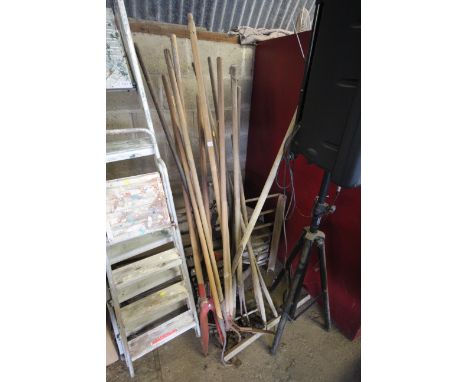 A large quantity of long handled garden tools to include hoes, rakes etc.