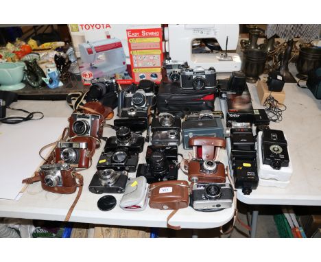 A collection of various vintage cameras including Olympus OM10