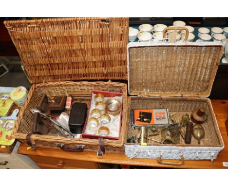 Two wicker baskets and contents to include flat irons, dominoes, scale weights, drinking glasses, various brass items, a nove