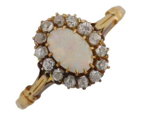 An opal and diamond oval cluster ring, unmarked gold settings, oval cabochon opal and old-cut diamonds, setting height 11.2mm