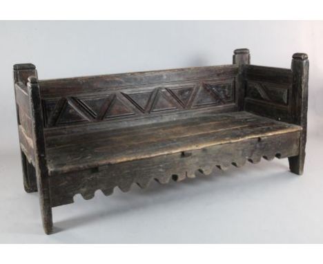 A 17th century Spanish chestnut settle, with geometric panelled back and sides, squab cushion, on stile feet, W.6ft 3in. D.2f