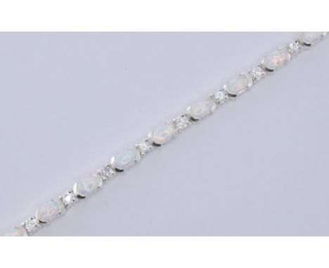 A silver opal and cz line bracelet. The bracelet being set with fifteen oval opal cabochons set with alternate round cut cz s