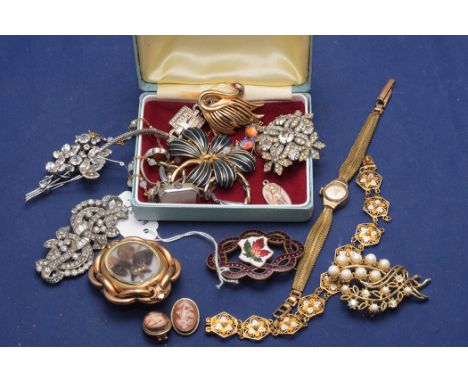 A Victorian mourning brooch with plaited hair decoration, in yellow metal mount; an enamel brooch; a pair of carved shell cam