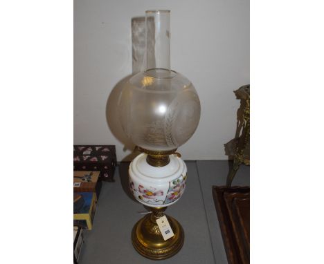 An oil lamp with acid etched shade and cream glass reservoir with hand decoration, on brass stand.
