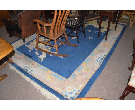 A 20th Century Chinese carpet, the blue ground decorated with dragon, flame and cloud decoration designs, 300 x 215cms.