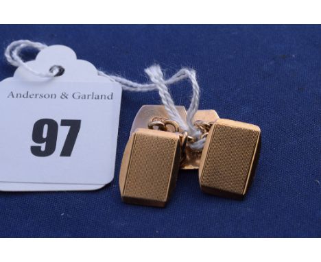 A pair of yellow metal cufflinks, stamped "9ct." with engine turned decoration and engraved initial "A", 6grms.