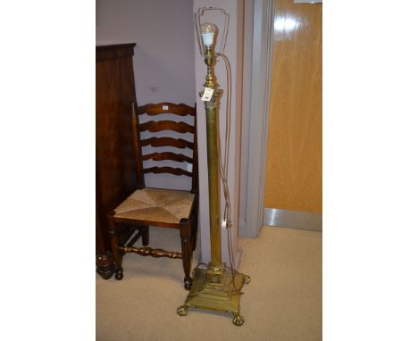 An early 20th Century brass corinthian column style standard lamp, raised on a square base terminating in claw and ball feet.