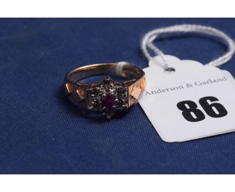 A ruby and diamond ring, star shaped mount on 9ct. yellow gold shank, 3.5grms gross.