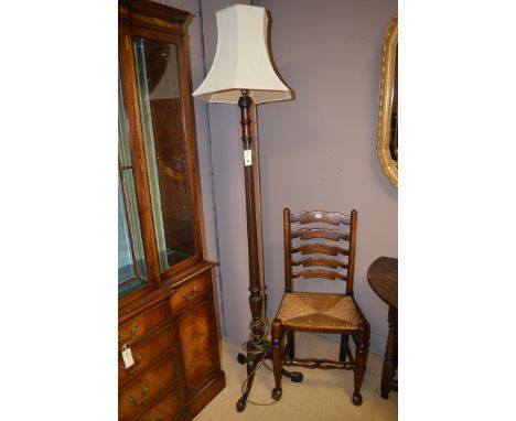A 20th Century mahogany standard lamp with fluted and reeded decoration, raised on tripod feet.