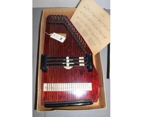 An auto harp, with music sheet, boxed.