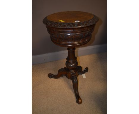 A Victorian carved walnut teapoy, the top opening to reveal two tea canisters (two missing), raised on turned and carved colu