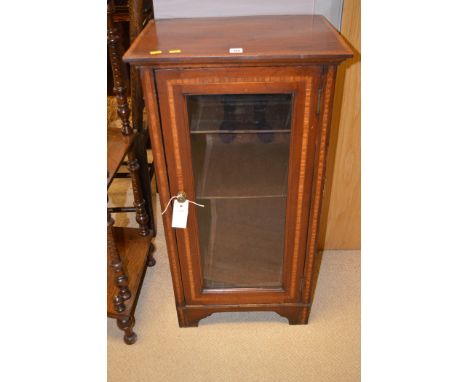 An Edwardian inlaid mahogany music cabinet, with bevelled glass panel door, raised on cut-out bracket feet, 45.5cms wide.