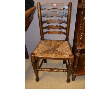 Six plus two 20th Century stained oak ladder back single dining chairs, with rush seats (two with high backs).