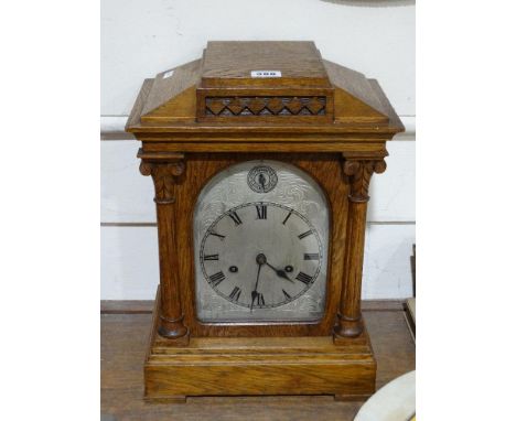     An Edwardian Oak Encased Bracket Clock With Arched Silvered Dial                