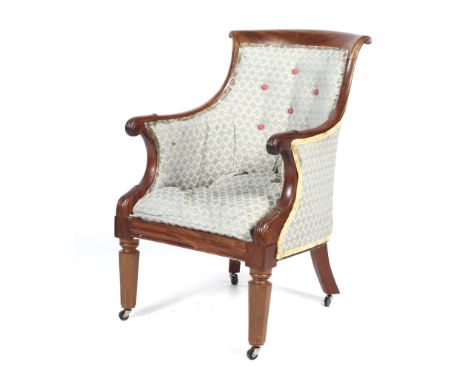A 19th century Regency style upholstered library armchair. With scroll top rail and a button back, scroll carved arms and ree