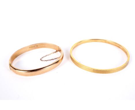 Two early 20th century gold bangles. Comprising; a rose gold hollow 'D' section hinged bangle, hallmarks for Chester 1916 and