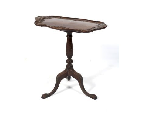 A late Victorian mahogany tilt-top tripod tea table. The scroll outline tray top carved with stylised birds of prey and flowe