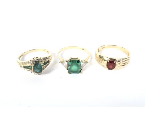 Three gem set dress rings. Comprising a 14ct gold, green and near colourless paste three stone ring, centred with a rectangul