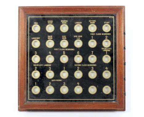 An early 20th century Country House Butler's bell board. With verre eglomise front in black and gilt, with thirty rooms, each