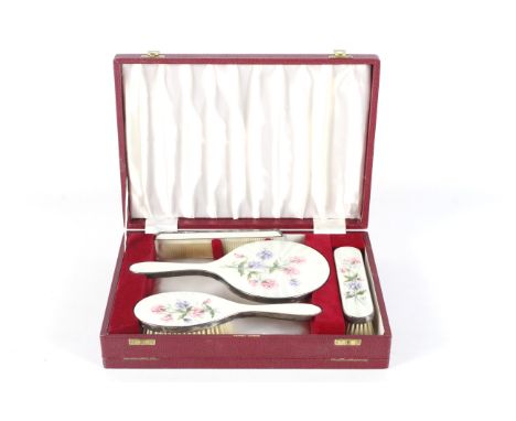 A four-piece silver and enamel dressing table set retailed by Asprey, London. All pieces by DCBS, London, comprising a comb, 