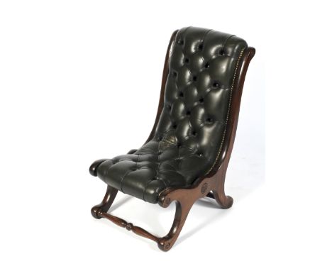 A contemporary leatherette button back 19th century style slipper chair with scrolled supports united by turned front and bac