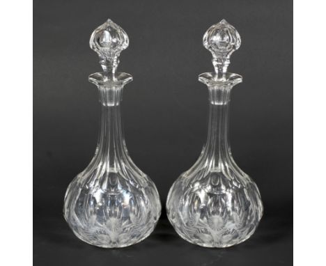 A pair of Victorian cut-glass shaft and globe decanters and stoppers. Each panel and lens cut, 33cm high