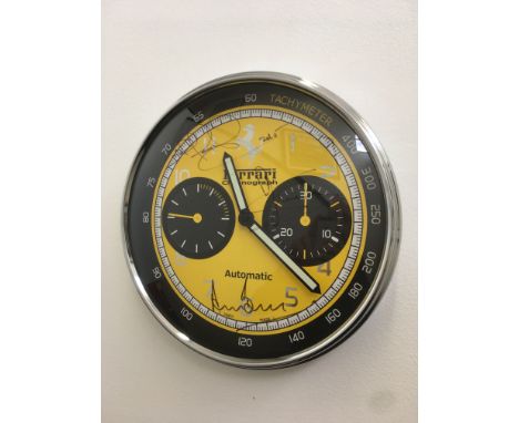 A chronograph style Ferrari clock with yellow dial face, signed by Derek Bell MBE, Nigel Mansell CBE and Jody Scheckter, 30cm