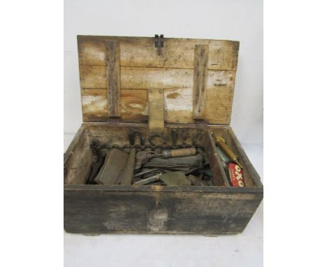 A wooden tool trunk containing various vintage tools