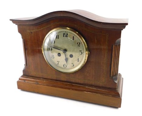 An Edwardian mahogany and chequer banded mantel clock, with a shaped top, silvered dial, on a plinth, 27cm high. 