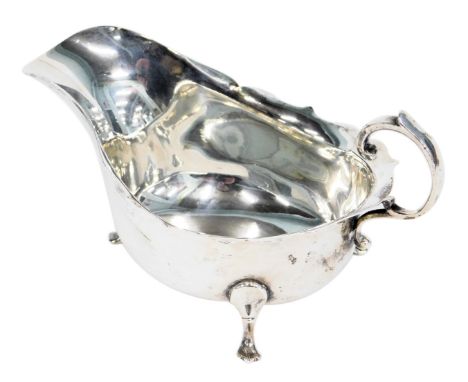 A George V silver sauce boat, with a fluted border and arched handle on tripod claw feet, Birmingham 1927, 2.89oz. 