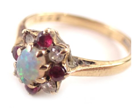 A 9ct gold cluster ring, set with central oval opal in eight claw setting, surrounded by garnets and CZs, on a yellow metal b