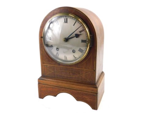 A 19thC mahogany and boxwood strung mantel clock, with a silvered dial, and an arched case, 30cm high.